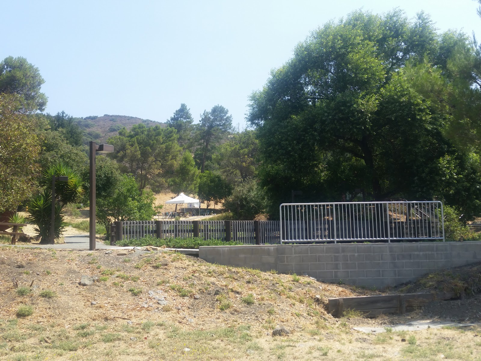 Exterior view of main building entrance with parking lot, fencing, and surrounding grounds