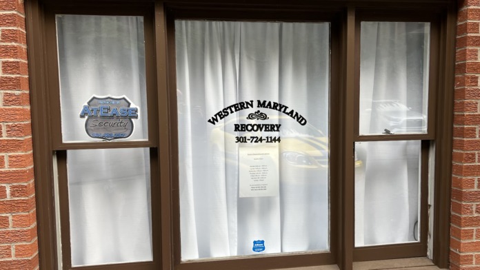 Exterior view of Western Maryland Recovery facility entrance with brick facade, window signage, and contact information displayed