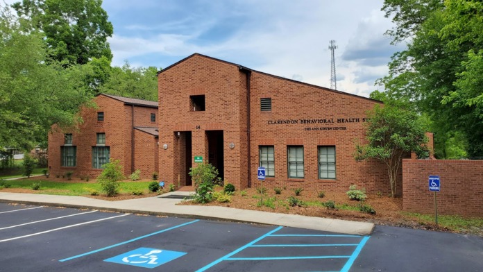 Exterior view of Clarendon Behavioral Health Services brick building with main entrance, accessible parking, and facility signage