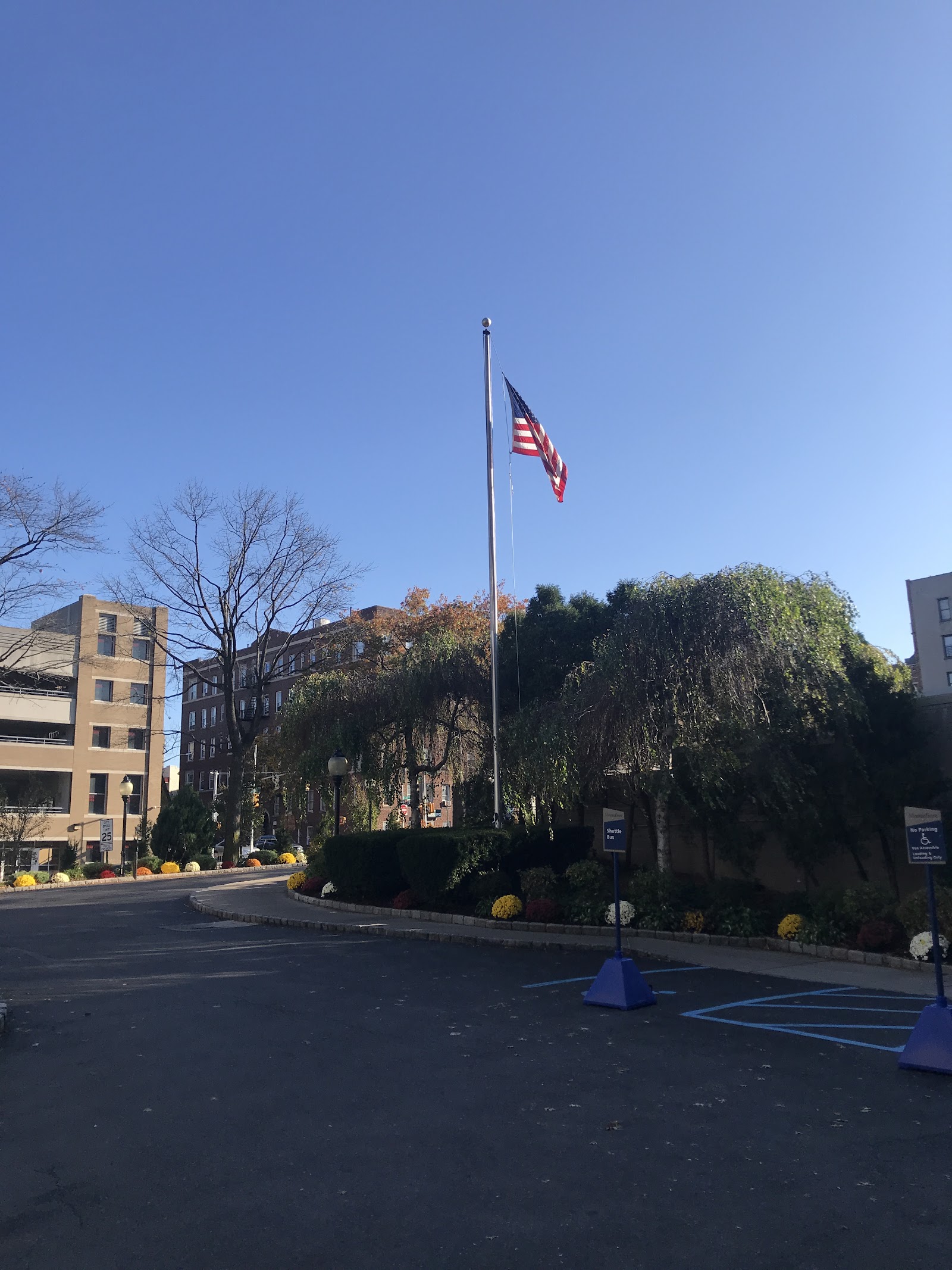 Outdoor view of medical center with American flag, landscaped grounds, and building exterior with clear sky