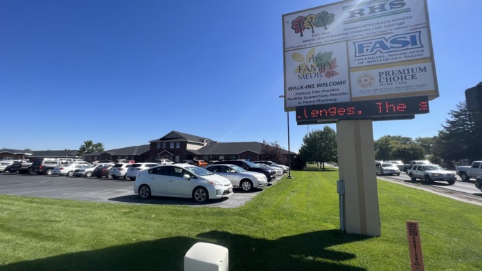 Exterior view of treatment facility with parking lot, RHS signage, and multi-unit brick building with landscaping