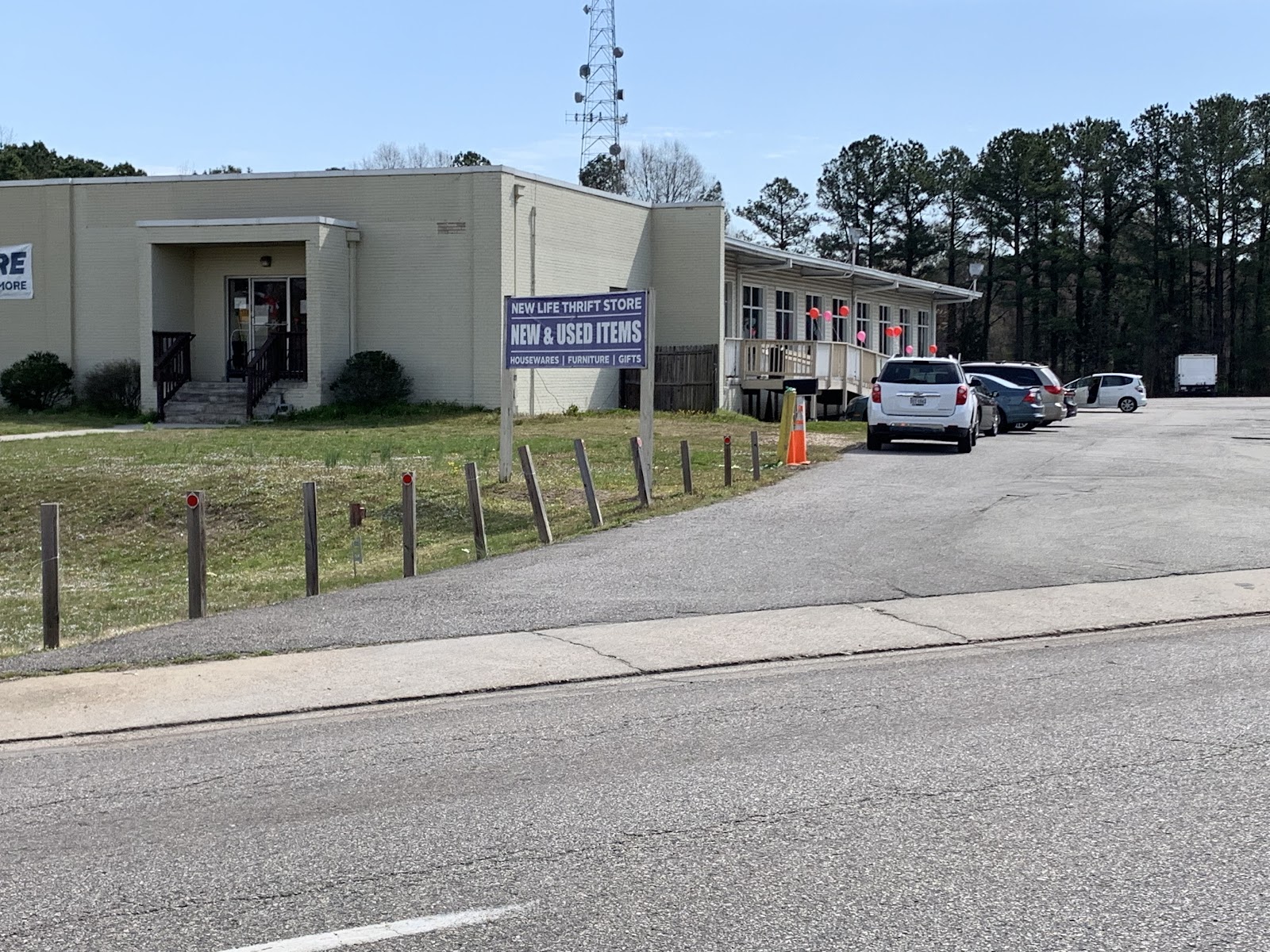 Exterior view of treatment facility buildings with parking area, landscaping, and adjacent thrift store signage
