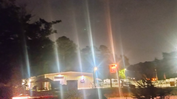 Exterior nighttime view of treatment center building with illuminated signage and landscape lighting
