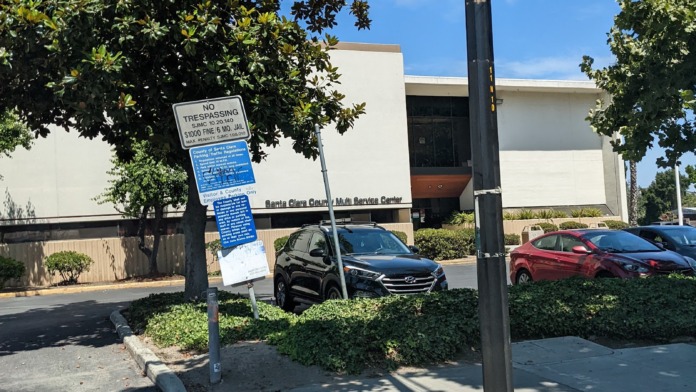 Exterior view showing facility building with adjacent parking area and landscaped grounds