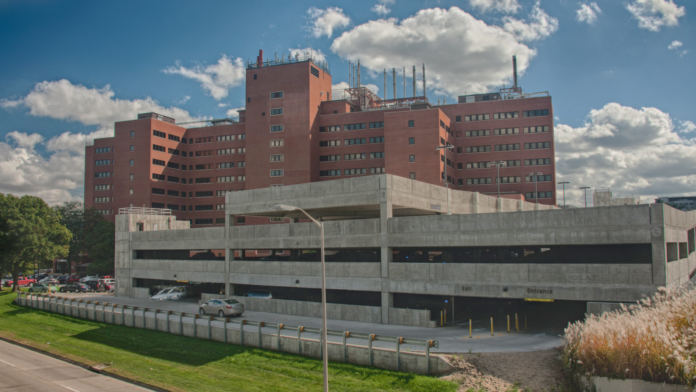 Exterior showing multi-story brick medical facility building with large concrete parking structure at street level