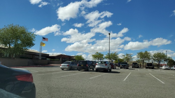 Exterior daytime view showing front entrance, brick building facade, flagpole, landscaping, and parking area