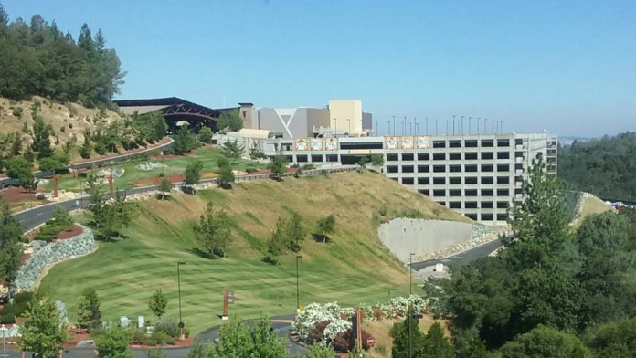 Exterior view of treatment center facility with manicured grounds, parking areas, and surrounding hillside landscaping