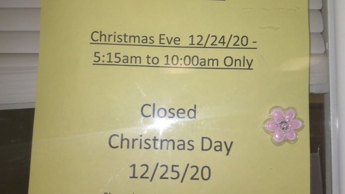Interior signage displaying Lakeside Clinic holiday hours on yellow posted notice with facility name and closure dates