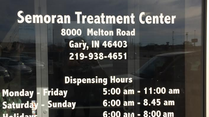 Exterior window signage displaying Semoran Treatment Center address, phone number, dispensing and operation hours