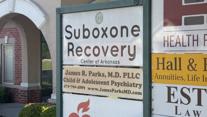 Exterior sign showing Suboxone Recovery Center of Arkansas branding with contact information and associated service logos