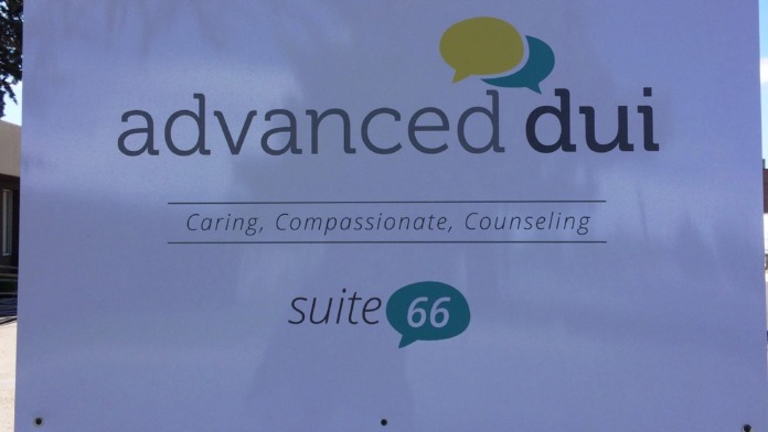 Outdoor ground sign displaying Advanced DUI facility name, caring tagline, and suite 66 location with logo