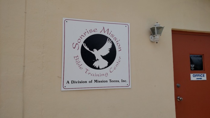 Interior view of facility office with Sonrise Mission signage, light fixtures, and office door
