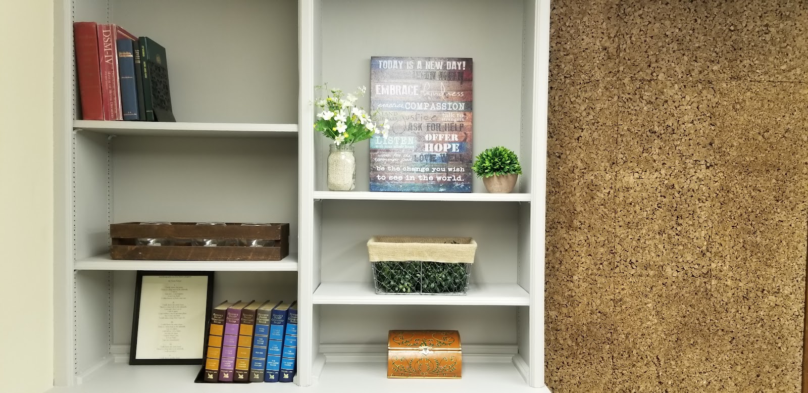 Interior shelving unit with books, motivational signage, and decorative items in facility
