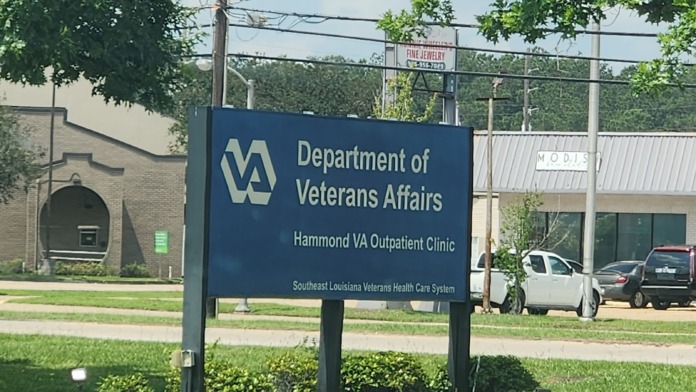 Exterior sign for Hammond VA Outpatient Clinic with landscaping, grass grounds, and facility building visible in background