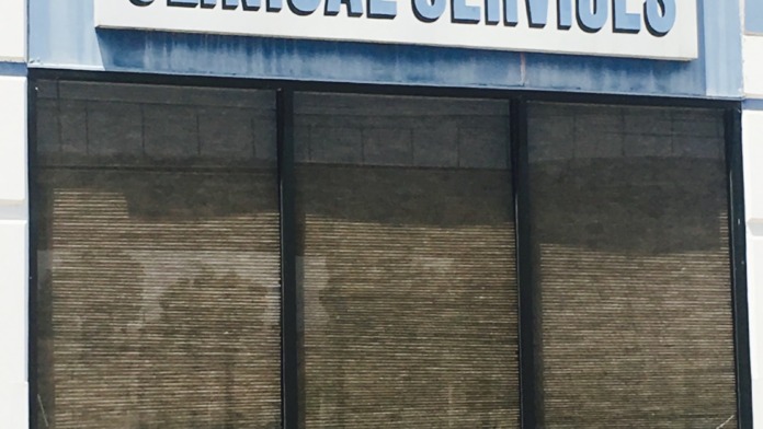 Exterior storefront signage reading Colton Clinical Services with metal frame and shuttered windows.