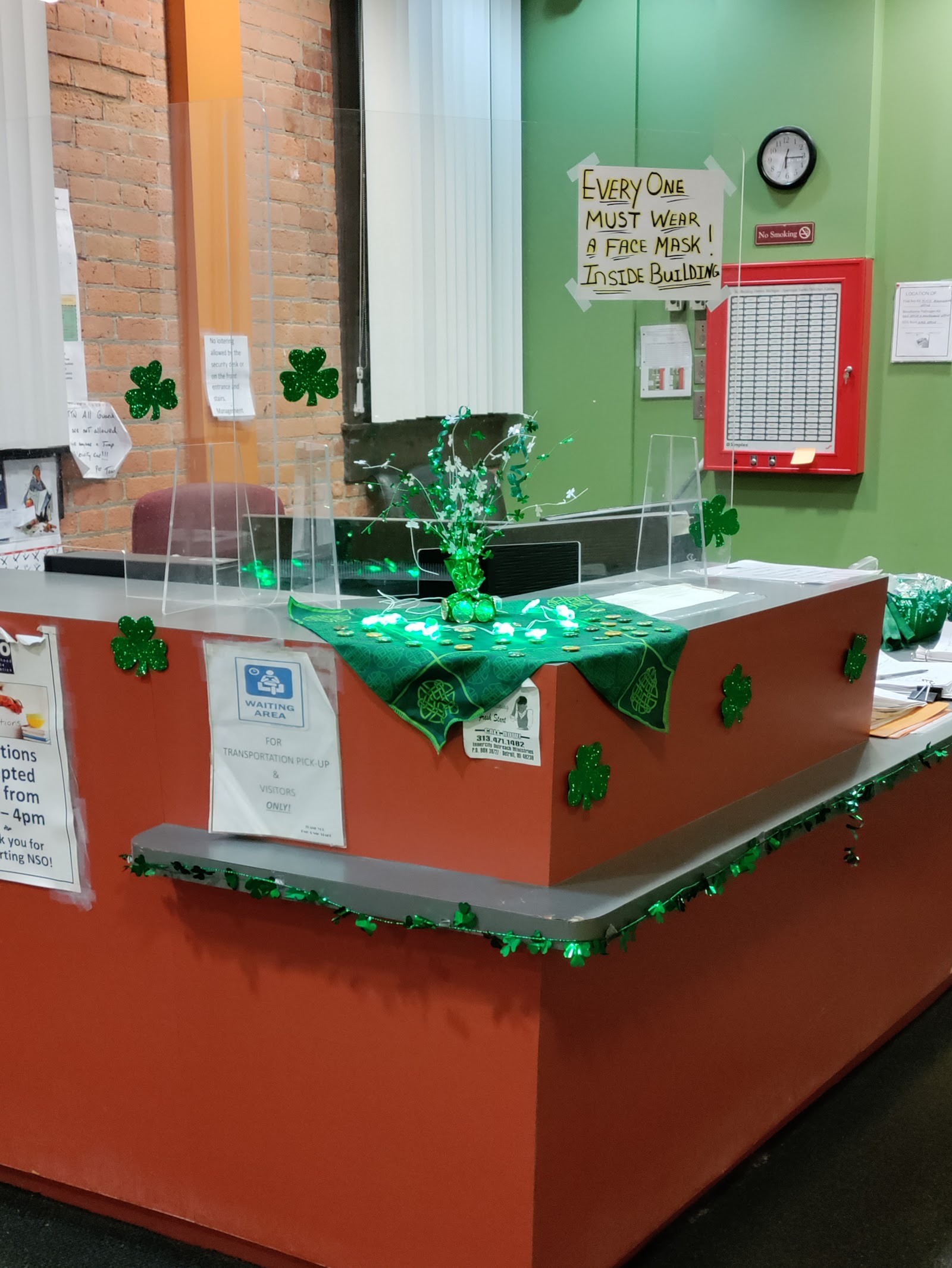 Interior reception desk with red and green accent walls, decorative holiday elements, and informational signage