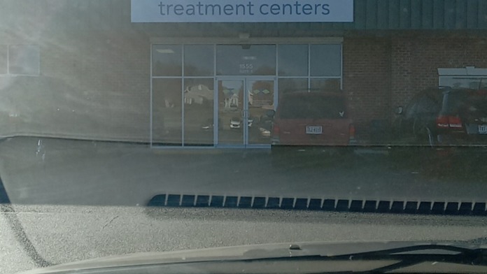 Exterior building view showing Crossroads Treatment Centers facade with glass entrance doors and parking lot area