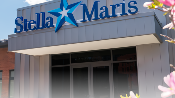 Exterior closeup of Stella Maris facility blue star logo and entrance signage with flowers