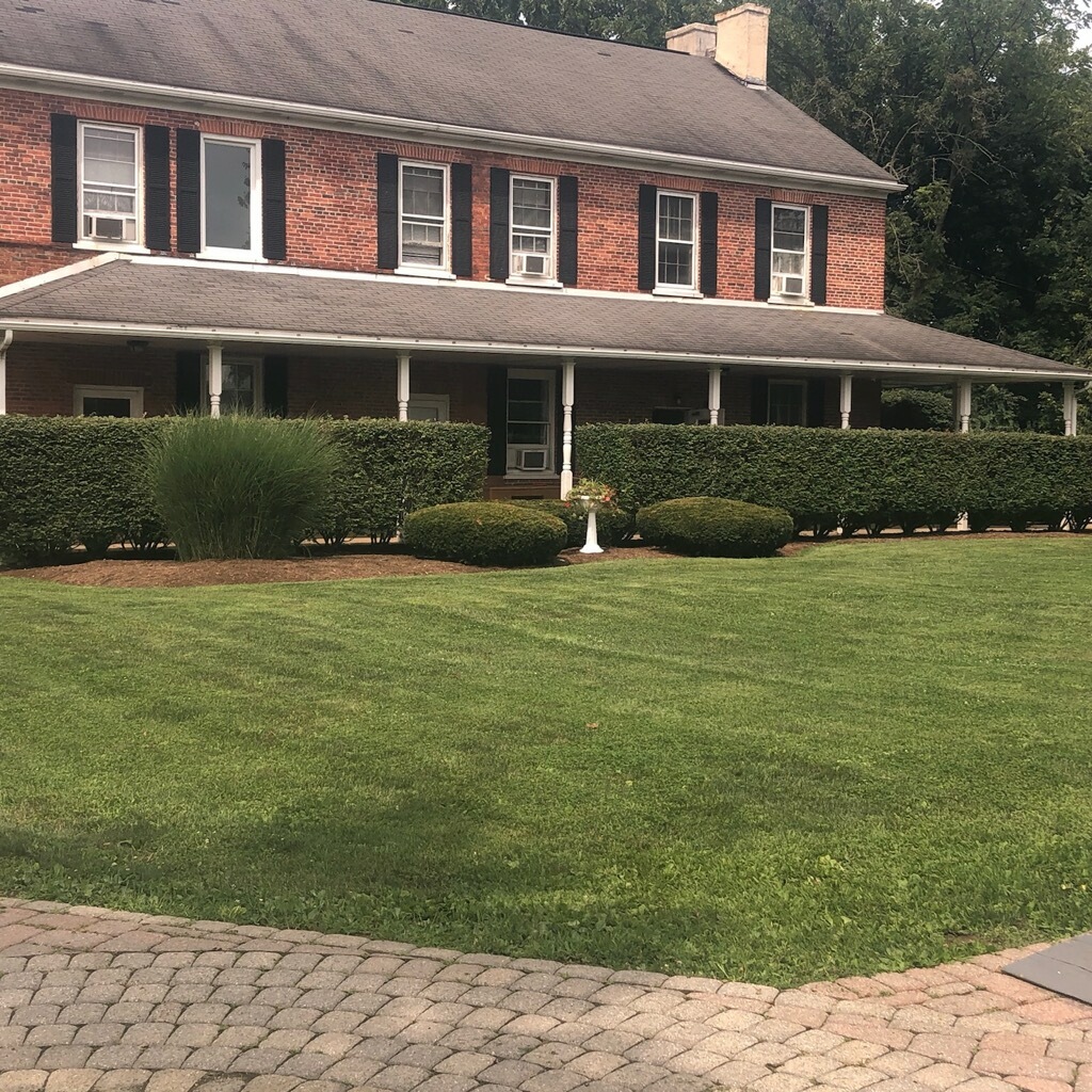 Exterior front facade of brick treatment facility with manicured lawn, decorative shrubs, and covered porch