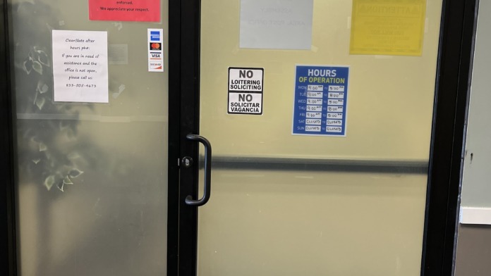 Interior entrance doors with CleanSlate Medical Group signage, hours of operation, and facility information posted