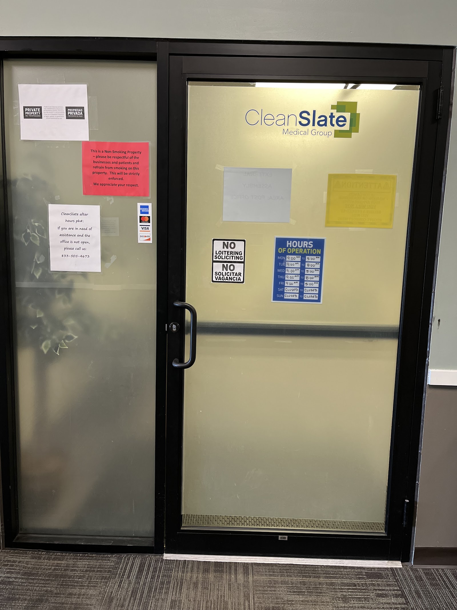 Interior entrance doors with CleanSlate Medical Group signage, hours of operation, and facility information posted