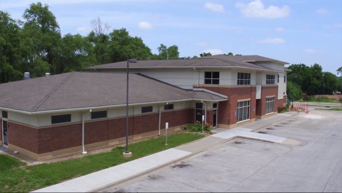 Exterior of medical facility showing front entrance, parking area, and contemporary brick architecture with professional signage