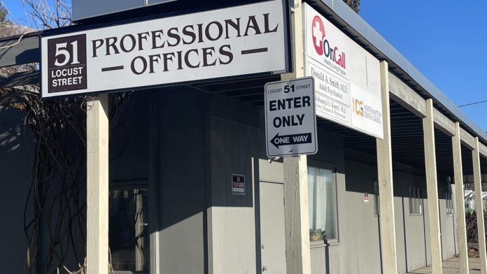 Exterior view of professional offices building entrance at 51 Locust Street with OnCall signage and parking area