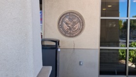 Exterior front entrance showing Department of Veterans Affairs official seal mounted on building facade and glass entry doors