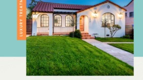 Exterior view of white Spanish-style building with red tile roof, arched windows, and manicured lawn