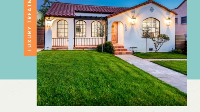 Exterior view of white Spanish-style building with red tile roof, arched windows, and manicured lawn