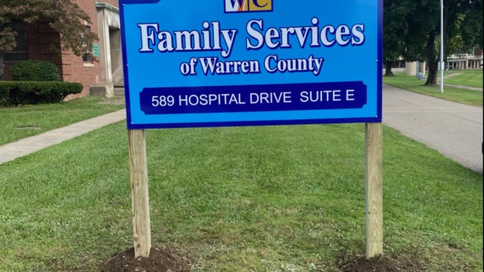 Exterior view of brick facility building with blue Family Services signage, address marker, and landscaped grounds