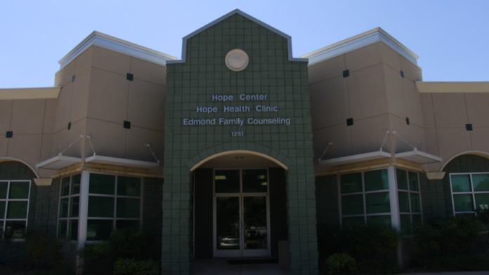 Exterior facade showing Edmond Family Counseling text signage, green tile lower section, cream upper section, and arched windows