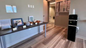 Interior reception desk with counter seating area, decorative items, and water cooler in modern treatment center lobby