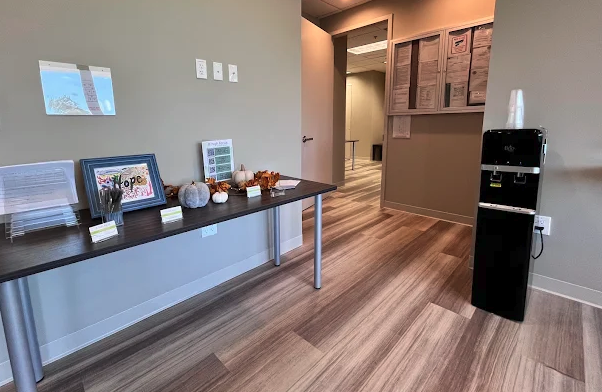 Interior reception desk with counter seating area, decorative items, and water cooler in modern treatment center lobby