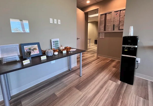 Interior reception desk with counter seating area, decorative items, and water cooler in modern treatment center lobby