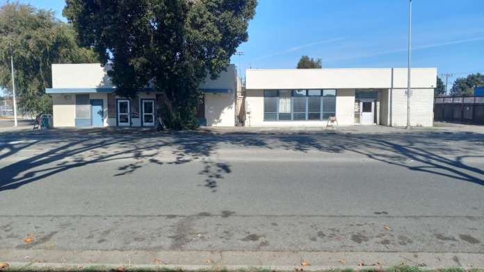 Exterior front view of treatment facility showing main building facade with white walls, windows, entrance, and street parking area
