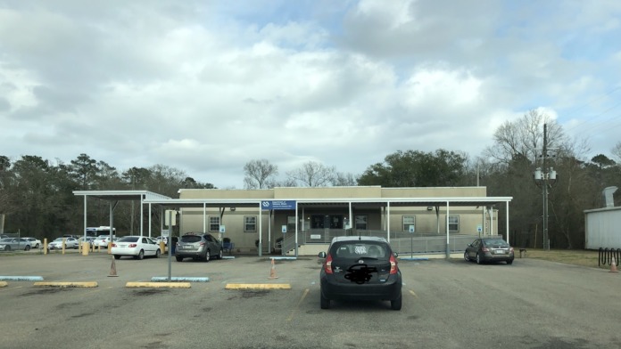 Complete exterior view of Hammond VA Clinic building with covered parking areas, multiple entrances, and landscaped grounds