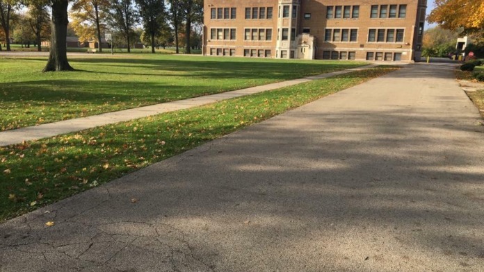 Exterior grounds showing mature trees with fall colors, landscaped area with stone features