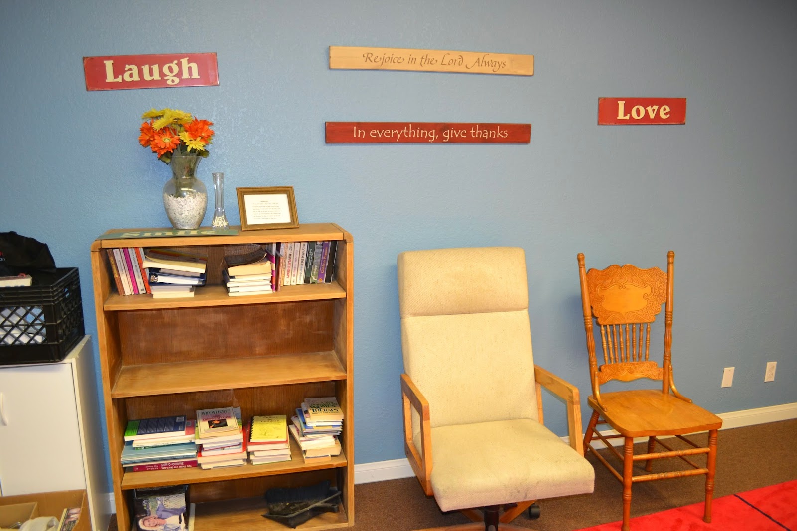 Interior counseling space with comfortable seating, bookshelf, framed materials, and inspirational wall signage