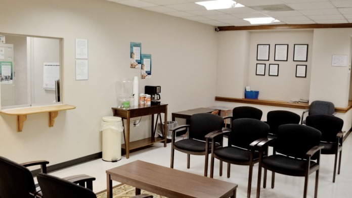 Interior meeting room with multiple chairs arranged for group activities, windows, and bulletin board displays