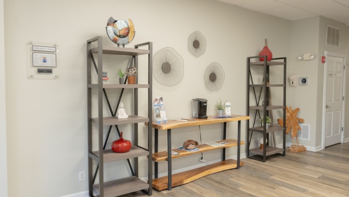 Interior therapy room with comfortable seating, circular chairs, floor lamps, and decorative wall art
