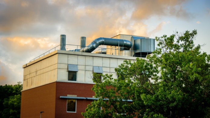 Exterior view of rooftop mechanical equipment including HVAC units and piping systems