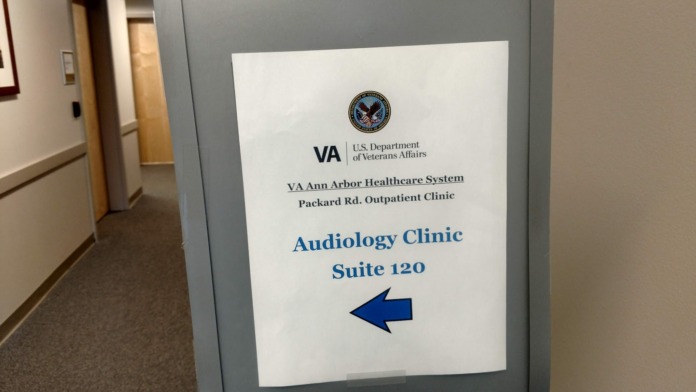 Interior hallway showing wayfinding signage for Audiology Clinic with VA Department of Veterans Affairs branding