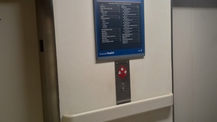 Interior close-up of elevator directory board showing hospital departments and floor locations