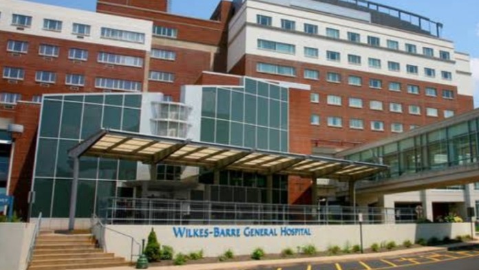 Exterior front entrance showing Wilkes-Barr General Hospital signage, glass doors, stone facade, and landscaping
