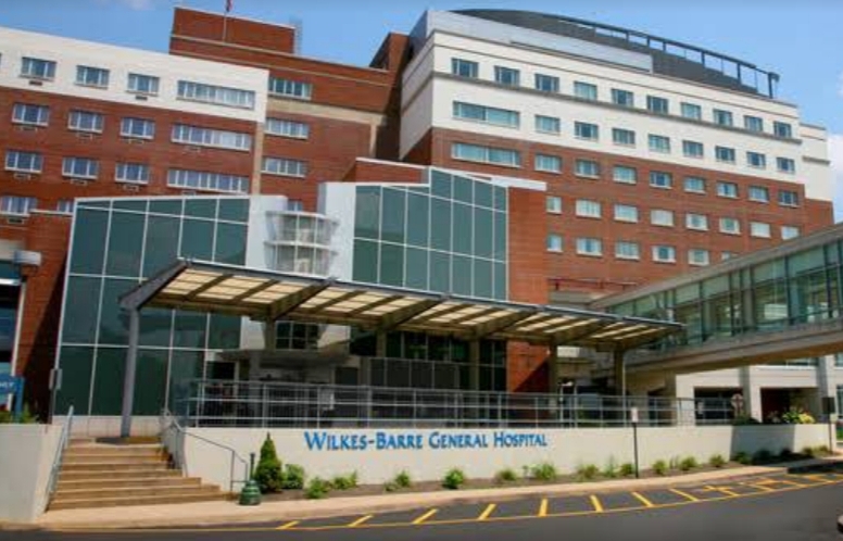 Exterior front entrance showing Wilkes-Barr General Hospital signage, glass doors, stone facade, and landscaping