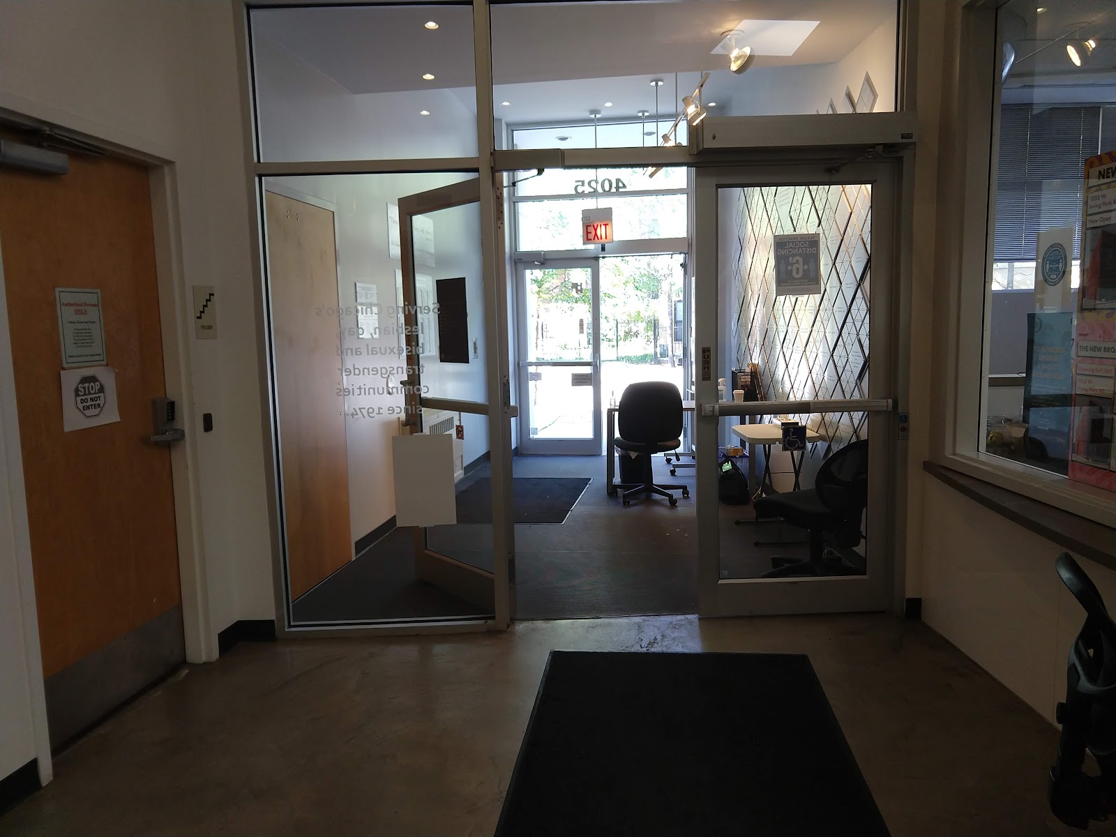 Interior entry hallway with glass doors, wooden entry portal, and access to facility spaces beyond