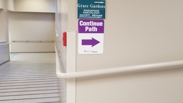 Interior hospital hallway with directional signage including Grace Gardens and Continue Path markers on walls
