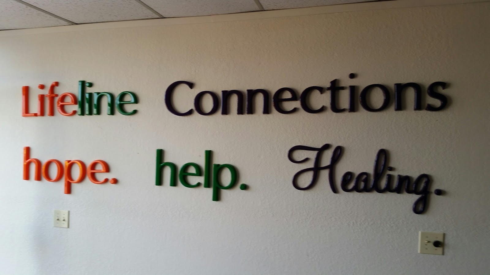 Interior wall displaying Lifeline Connections branding with mission statement in colorful text: hope, help, Healing