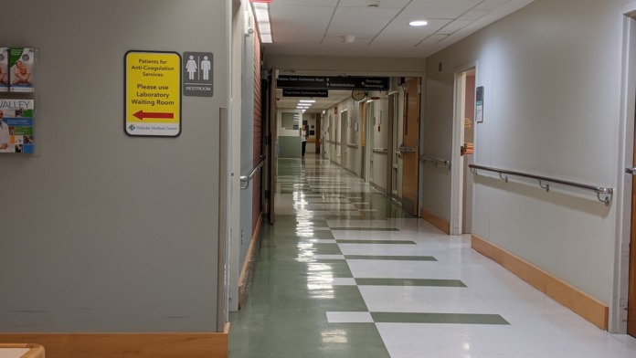 Interior medical department reception area with labeled desks for laboratory, MRI, and cardiology/neuro services